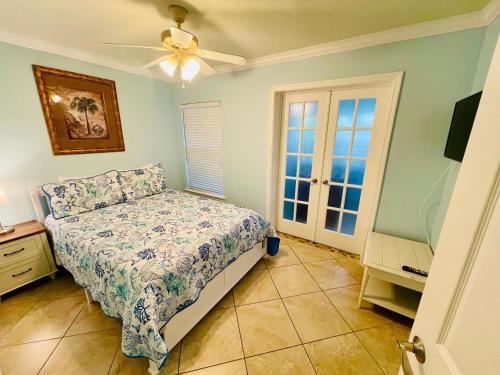 1 dormitorio con 1 cama y ventilador de techo en Beach Condo with Game Room Steps To Beach, en Clearwater Beach
