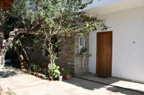 a door to a house with a tree next to it at Blue Fox 1 in Chrani
