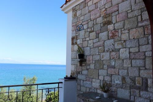 a stone wall with the ocean in the background at Blue Fox 1 in Chrani