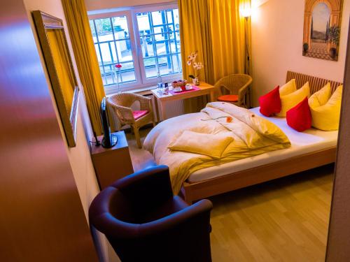 Schlafzimmer mit einem Bett mit gelben und roten Kissen in der Unterkunft The Soho Hotel Altstadt in Düsseldorf
