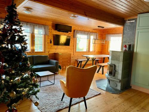 a living room with a christmas tree in a room at Log cabin in 15 min from Rovaniemi center- 3bdr-Sauna-Fireplace in Rovaniemi