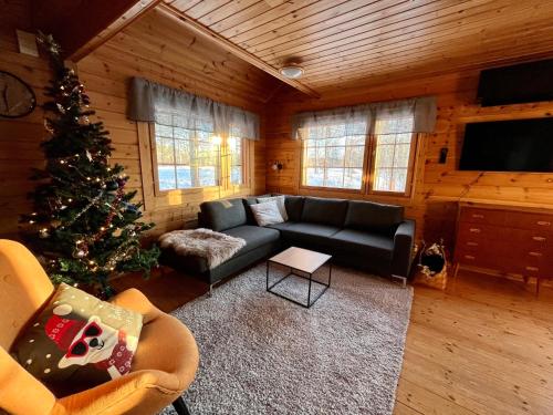 a living room with a christmas tree and a couch at Log cabin in 15 min from Rovaniemi center- 3bdr-Sauna-Fireplace in Rovaniemi