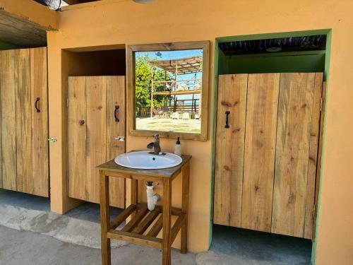 a bathroom with a sink and two wooden doors at Beach Terrace Loft in Buen Hombre in Buen Hombre