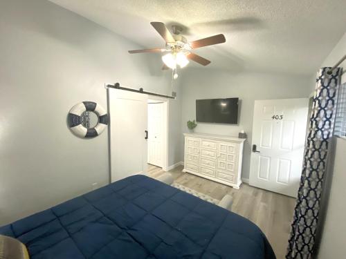 a bedroom with a blue bed and a ceiling fan at B Lakefront! Remodeled, Boat Slip, Patio Views, Pool, Boat Ramp, WIFI in Osage Beach