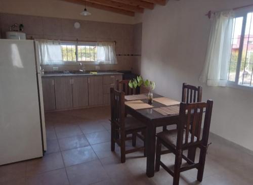 een keuken met een tafel en stoelen en een koelkast bij La venecia in Guaymallen
