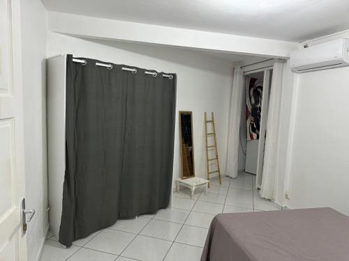 a bedroom with a black shower curtain in a room at Domaine de la villa d’orge in Vieux-Habitants