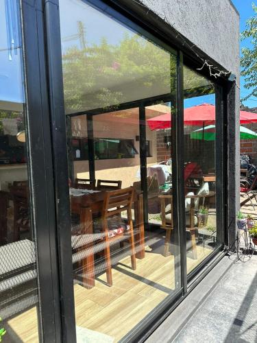a glass window of a patio with a table and chairs at Hospedaje posada en Ezeiza in Ezeiza