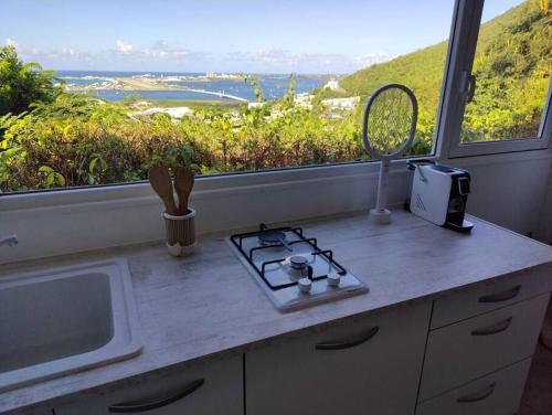 a kitchen with a counter with a stove and a window at Cole Bay Retreat in Koolbaai