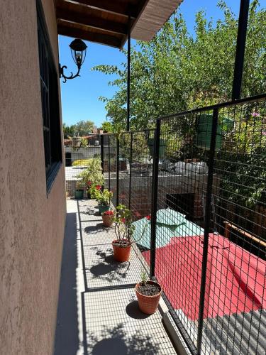 a balcony with potted plants and a fence at Hospedaje posada en Ezeiza in Ezeiza