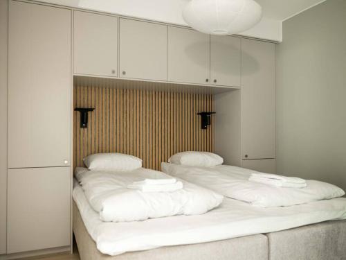 two twin beds in a room with white cabinets at Chic Are Apt for 6 Ski-in-Ski-out with Sauna in Åre