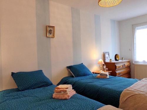 Grumesnil的住宿－Gîte Formerie, 3 pièces, 4 personnes - FR-1-526-45，一间卧室配有两张蓝色的床和梳妆台。