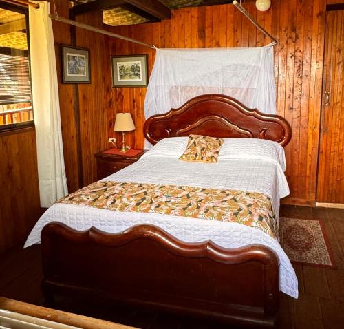 a bedroom with a large bed with a wooden wall at Posada Turística Rocas De Cabo Marzo in Bahía Solano
