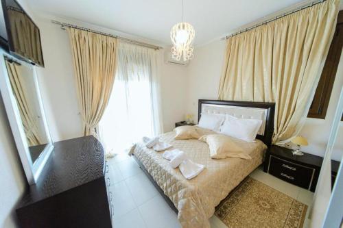 1 dormitorio con 1 cama con toallas en Villas Hanioti, en Chaniotis