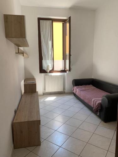 een woonkamer met een bank en een raam bij Pier’s House in Garbagnate Milanese