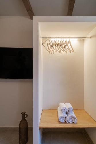 a room with a shelf with towels and a vase at Mountain Mini Suite in Áyioi Dhéka