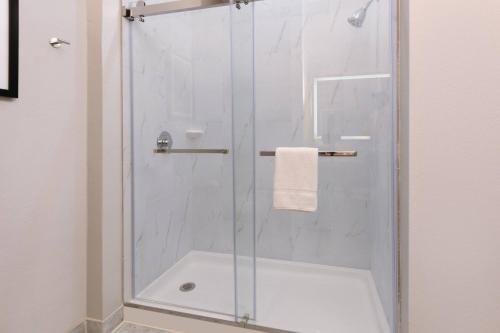 a shower with a glass door in a bathroom at The Elm, a Ramada by Wyndham in Little Elm