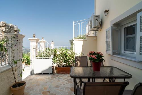 a balcony with a table with flowers on it at Mountain Mini Suite in Áyioi Dhéka