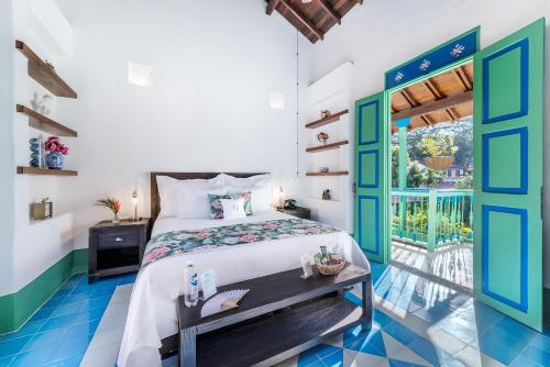 a bedroom with a bed and a door to a courtyard at Casa Cedrela Hotel Boutique by HMC -Cauca Viejo- Mayores de 14 años in Jericó