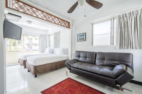 sala de estar con 2 camas y sofá en Stay Condominiums Waikiki, en Honolulu