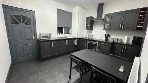 a large kitchen with a table and a door at Modern 2 Bed near Turf Moor Football Stadium, Parks, Canal and Lake in Burnley
