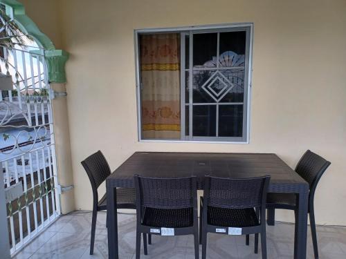 a table and chairs in front of a window at 1 bdrm1 1 bath in Old Harbour