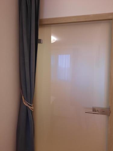a sliding glass door with a curtain in a room at Apartmán Vital na Pálavě - ubytování & životní restart in Pasohlávky