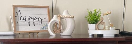 two white vases and a picture on a table at Serenity Get Away in Lucea