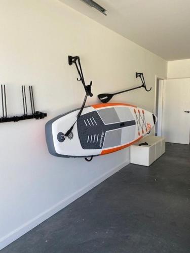 a surfboard hanging on a wall in a room at Lake Villavista - 4BR Luxury Townhouse l Pet Friendly l Lake Views l WiFi l BBQ in Jindabyne