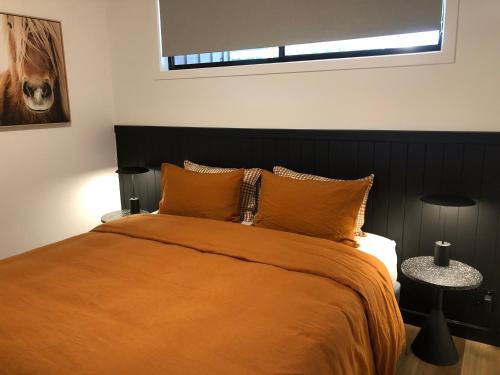a bedroom with a bed with an orange bedspread at Selah Valley Estate in Limpinwood