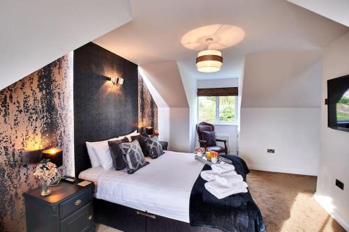 a bedroom with a bed with a black accent wall at The Chase, Luxury Hot Tub Retreat, Pets Welcomed in Dipton
