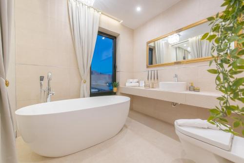 a bathroom with a large white tub and a window at Samstag Split in Split