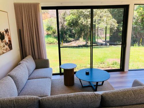 a living room with a couch and a table at Selah Valley Estate in Limpinwood