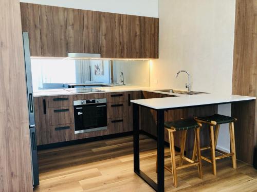 a kitchen with wooden cabinets and a island with bar stools at Selah Valley Estate in Limpinwood