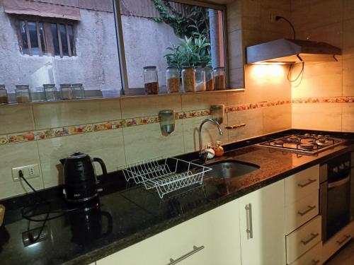 uma bancada de cozinha com um lavatório e um lavatório em Casa en Viña del Mar em Viña del Mar