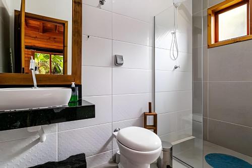 bagno bianco con servizi igienici e lavandino di Cabanas aconchegantes. Desfrute da natureza e praia a Florianópolis