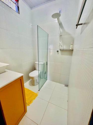 a bathroom with a toilet and a glass shower at Casa de Praia Tutóia in Tutóia