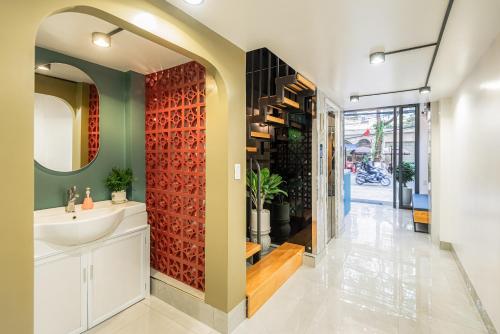baño con lavabo y pared roja en GARE D'47 Homestay/ Hotel, en Hai Phong