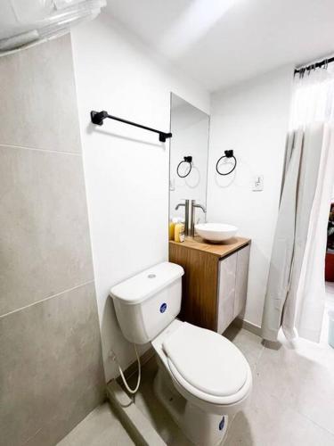 ein weißes Bad mit einem WC und einem Waschbecken in der Unterkunft Moderna Casa Familiar in Yopal