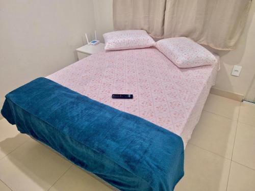 a small bed with a pink and blue comforter at Studio #3 Rubi in Campos dos Goytacazes