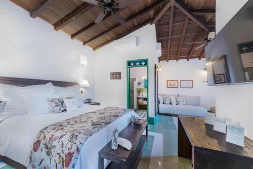 a bedroom with a large bed and a desk at Casa Cedrela Hotel Boutique by HMC -Cauca Viejo- Mayores de 14 años in Jericó