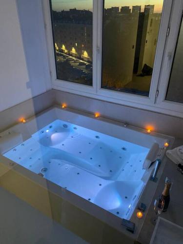 d'une baignoire avec vue sur la ville. dans l'établissement Suite « BODY LOVE » - Jacuzzi privatif, à Créteil