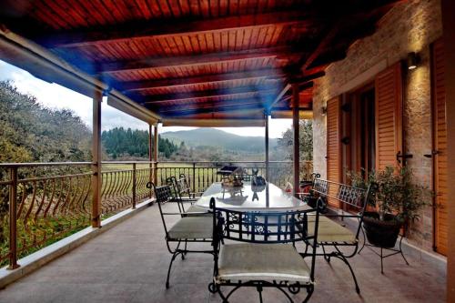 patio con mesa y sillas en el balcón en Ktima Karadimou, en Karkaloú
