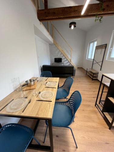 une table et des chaises dans une pièce avec piano dans l'établissement Appartement confort à Cholet, à Cholet
