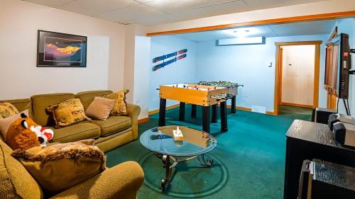 a living room with a couch and a table with a foos ball at Polar Peak Chalet by Fernie Lodging Company in Fernie