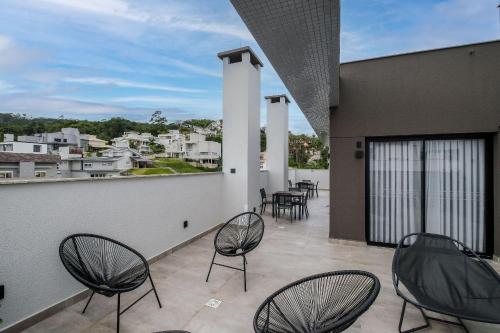 un patio con sillas y mesas en un balcón en ARE - apartamentos próximos ao centro, en Florianópolis