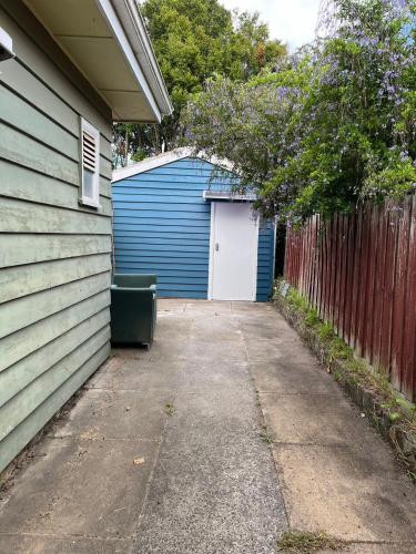 een blauwe garage met een witte deur naast een hek bij Master Bedroom opposite to Deakin University in Burwood