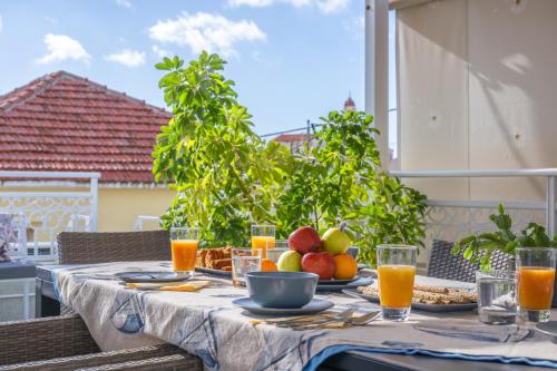 a table with fruit and juice on a patio at Boutique Villa Aspasia in Lixouri