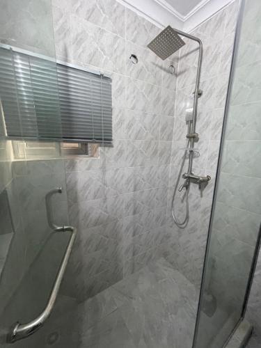 a bathroom with a shower with a glass door at Plot 100 in Lagos