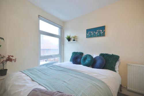 a bedroom with a bed with blue pillows on it at Curve Apartments in London
