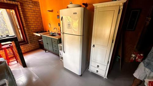 eine Küche mit einem weißen Kühlschrank und einer Spüle in der Unterkunft Pousada e Hostel Vale do Rosa in Praia do Rosa